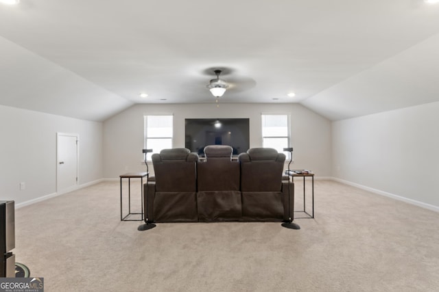 carpeted cinema room featuring lofted ceiling, ceiling fan, and baseboards