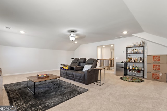 living area with lofted ceiling, carpet, and visible vents