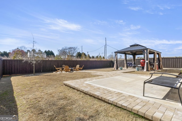 exterior space with a fenced backyard, a fire pit, a patio, and a gazebo