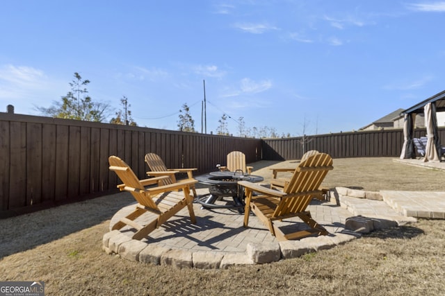 view of patio featuring a fenced backyard and a fire pit