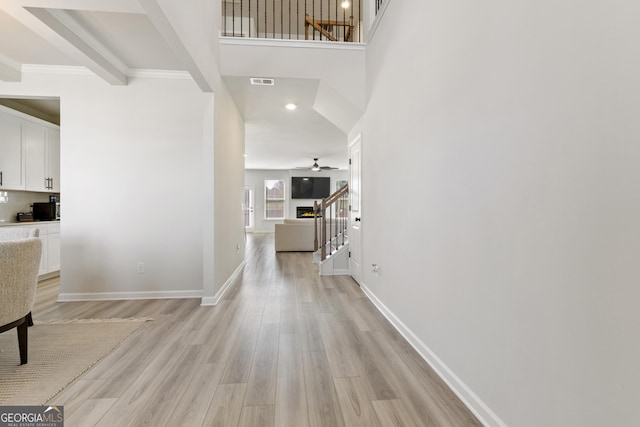 hall featuring stairs, light wood finished floors, visible vents, and baseboards