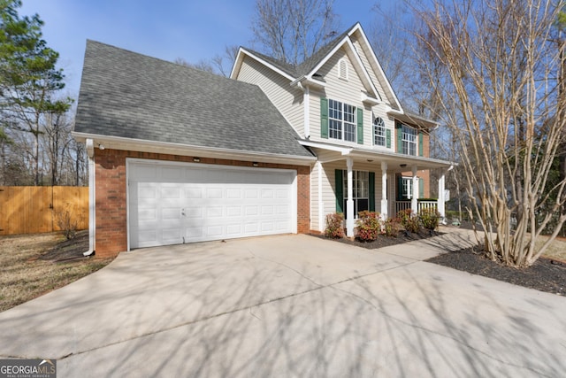 view of front facade featuring a porch, an attached garage, fence, driveway, and roof with shingles