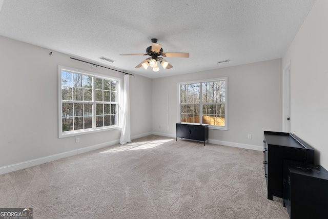 interior space with a wealth of natural light, carpet, and visible vents