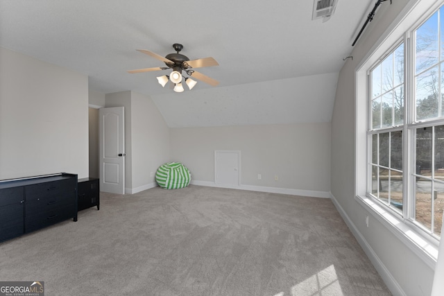 bonus room featuring lofted ceiling, visible vents, light carpet, ceiling fan, and baseboards