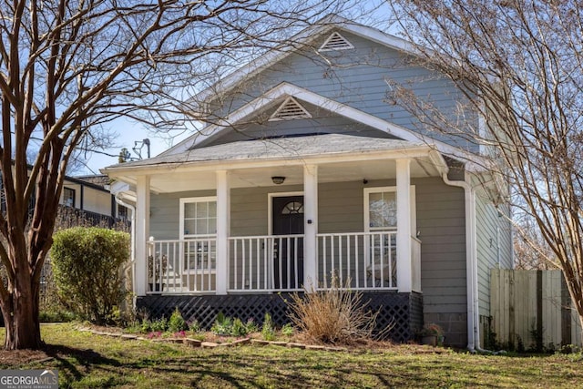 view of front of property with a porch and fence