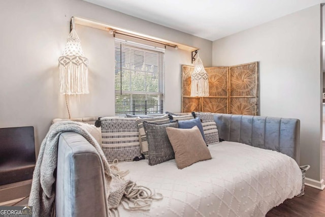 bedroom with wood finished floors and baseboards