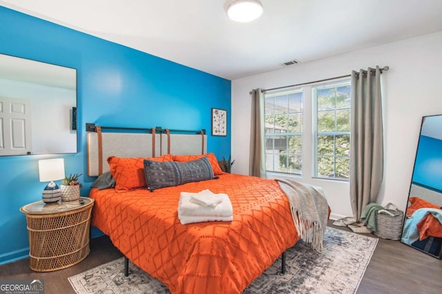 bedroom featuring visible vents and wood finished floors