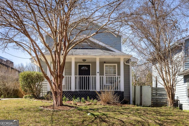 traditional style home featuring covered porch and a front lawn