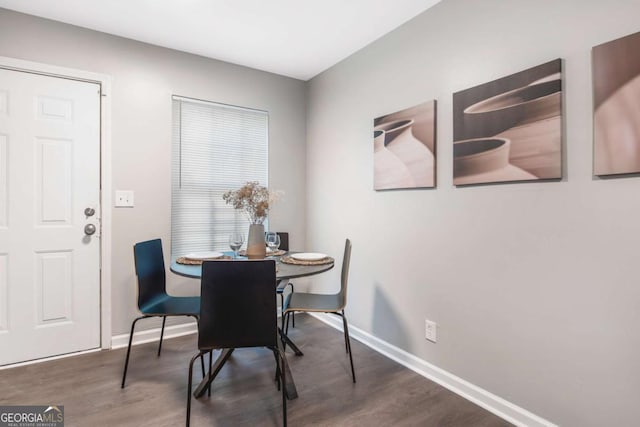 dining space with baseboards and wood finished floors