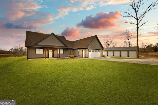 view of front of home with concrete driveway, a shingled roof, a lawn, and an attached garage