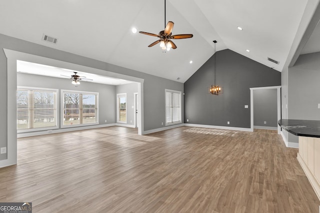 unfurnished living room with light wood-style flooring, visible vents, baseboards, and ceiling fan with notable chandelier