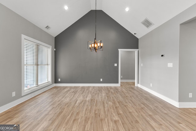 interior space with high vaulted ceiling, light wood-style flooring, visible vents, and an inviting chandelier