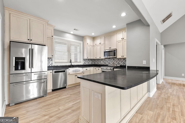 kitchen featuring appliances with stainless steel finishes, visible vents, a peninsula, and cream cabinets