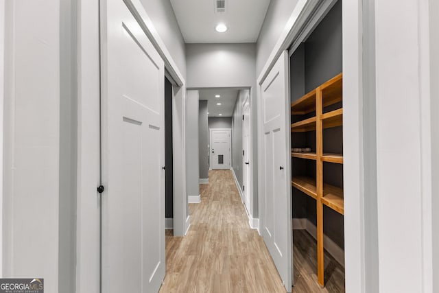 hallway featuring light wood finished floors, recessed lighting, visible vents, and baseboards