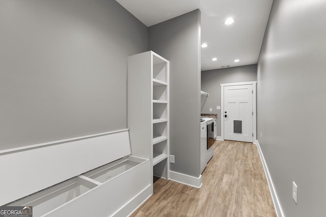 interior space featuring recessed lighting, light wood-type flooring, washing machine and clothes dryer, and baseboards