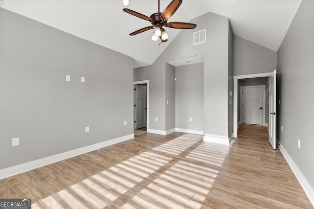 interior space with light wood-style floors, baseboards, visible vents, and high vaulted ceiling