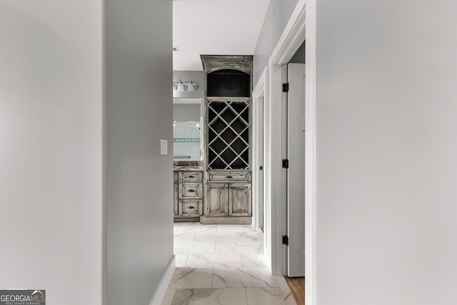 corridor with marble finish floor and baseboards