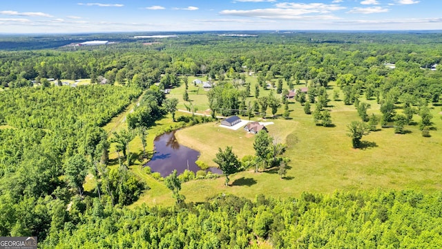 birds eye view of property with a water view and a wooded view