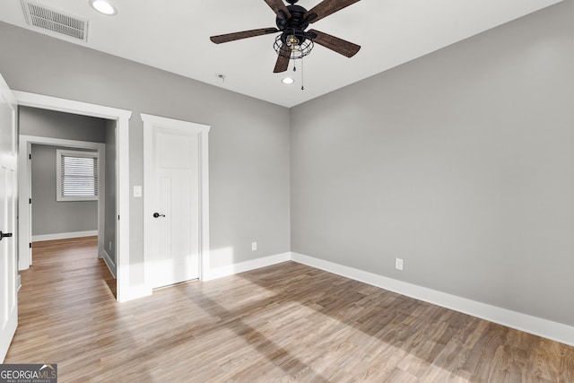 empty room featuring light wood-type flooring, visible vents, baseboards, and recessed lighting