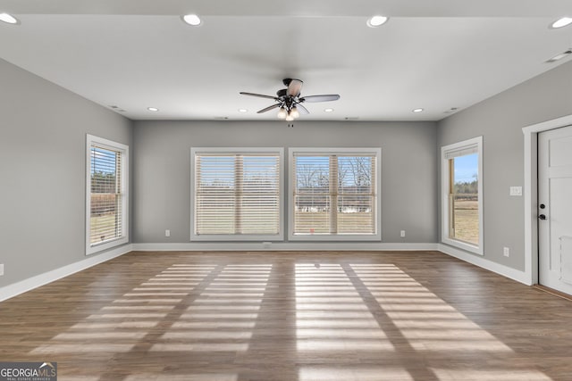 unfurnished living room with baseboards, wood finished floors, visible vents, and recessed lighting