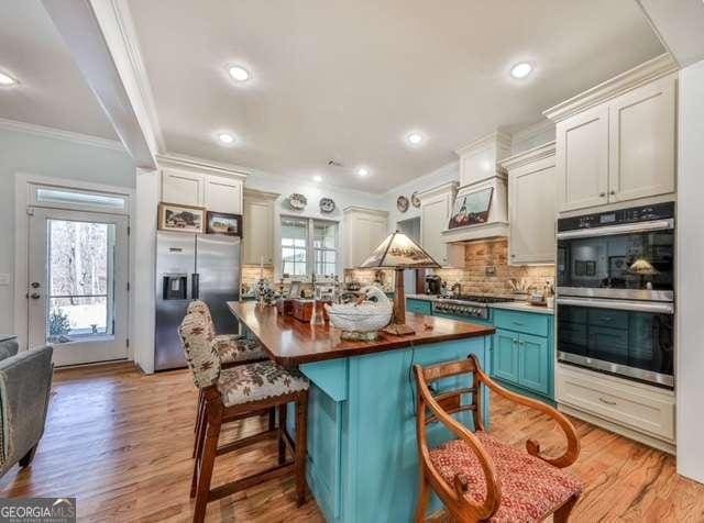 kitchen with stainless steel appliances, a wealth of natural light, and light wood-type flooring