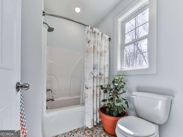 bathroom featuring shower / bathtub combination with curtain and toilet