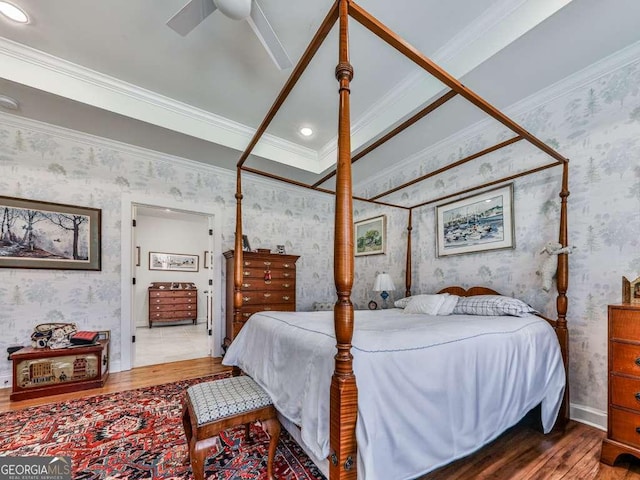 bedroom featuring wallpapered walls, baseboards, ceiling fan, wood finished floors, and crown molding