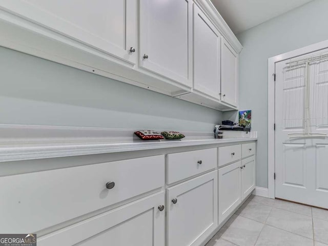 interior space with light tile patterned floors and baseboards