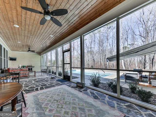 sunroom with wood ceiling and ceiling fan