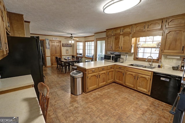 kitchen with light floors, light countertops, a sink, a peninsula, and black appliances