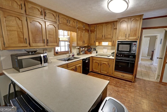 kitchen with light countertops, a sink, a textured ceiling, a peninsula, and black appliances