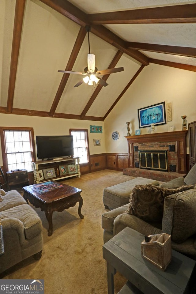 living area featuring carpet floors, a wainscoted wall, a fireplace, and a wealth of natural light