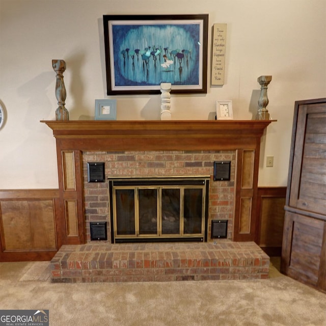 interior details featuring carpet, a wainscoted wall, a fireplace, and visible vents