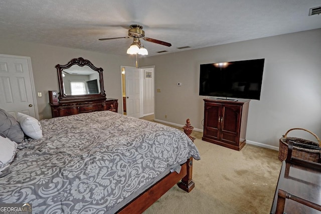 bedroom with a textured ceiling, a ceiling fan, visible vents, baseboards, and carpet