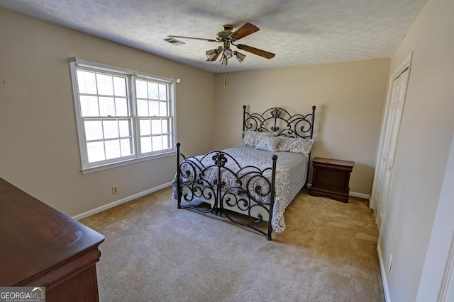 carpeted bedroom featuring visible vents, ceiling fan, a textured ceiling, and baseboards