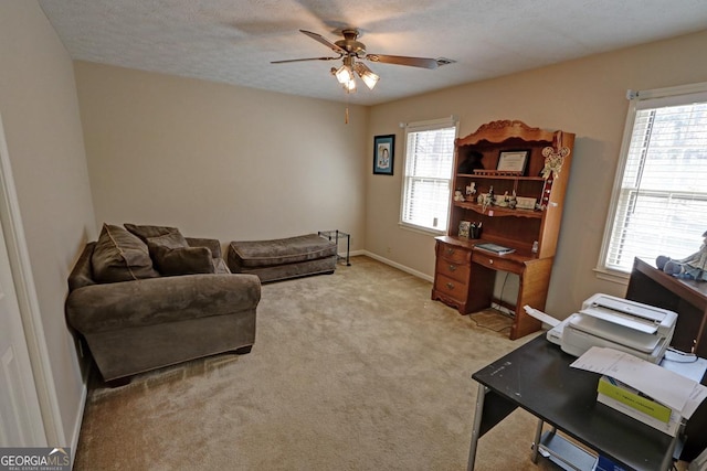 home office with light carpet, a textured ceiling, a wealth of natural light, and a ceiling fan