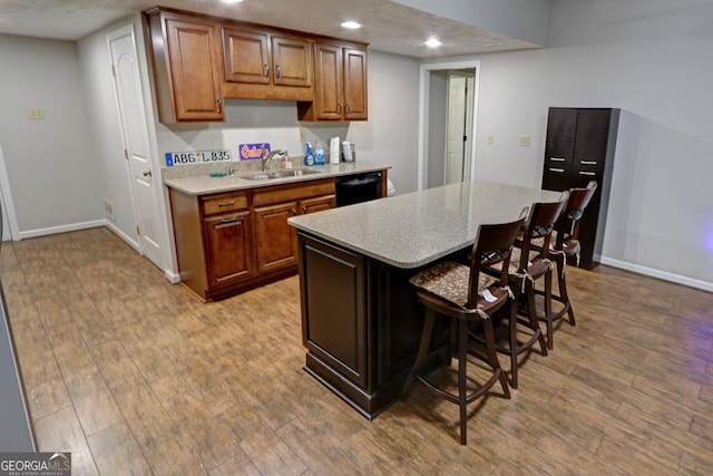 kitchen featuring wood finished floors, a sink, and baseboards