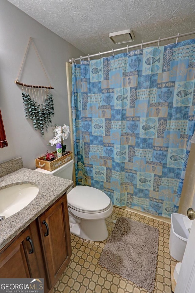 full bath with a textured ceiling, vanity, toilet, and a shower with curtain