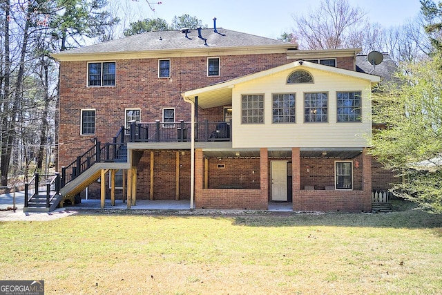 back of property featuring brick siding, a lawn, stairway, a patio area, and a wooden deck