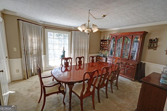 dining room with light carpet, an inviting chandelier, ornamental molding, and a textured ceiling