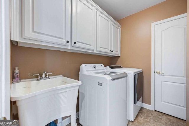 washroom with washer and clothes dryer, cabinet space, baseboards, and a sink