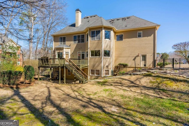 back of house featuring stairway, fence, a wooden deck, a yard, and a chimney