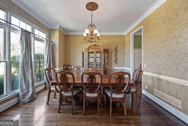 dining area with wallpapered walls, ornamental molding, visible vents, and a chandelier