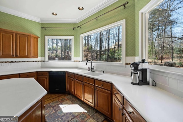 kitchen with wallpapered walls, light countertops, black dishwasher, and a sink