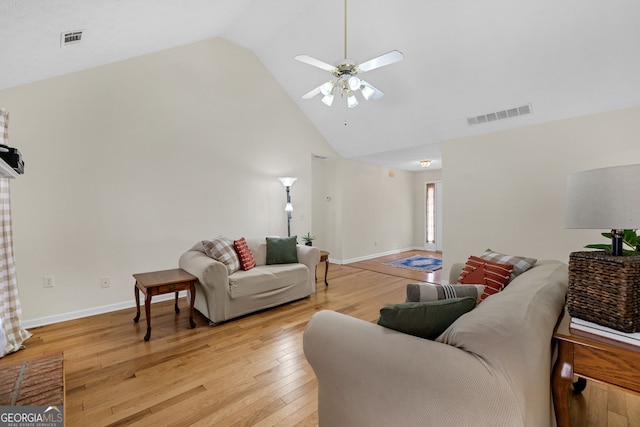 living area with high vaulted ceiling, light wood-type flooring, visible vents, and a ceiling fan