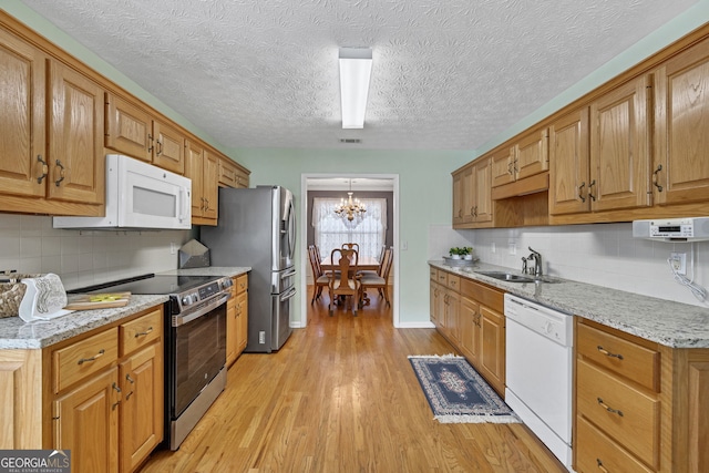 kitchen featuring a notable chandelier, a sink, visible vents, light wood-style floors, and appliances with stainless steel finishes