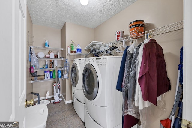 washroom featuring laundry area, separate washer and dryer, a textured ceiling, and tile patterned floors