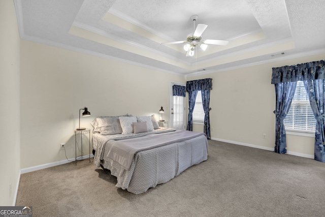 carpeted bedroom featuring multiple windows, baseboards, a raised ceiling, and ornamental molding