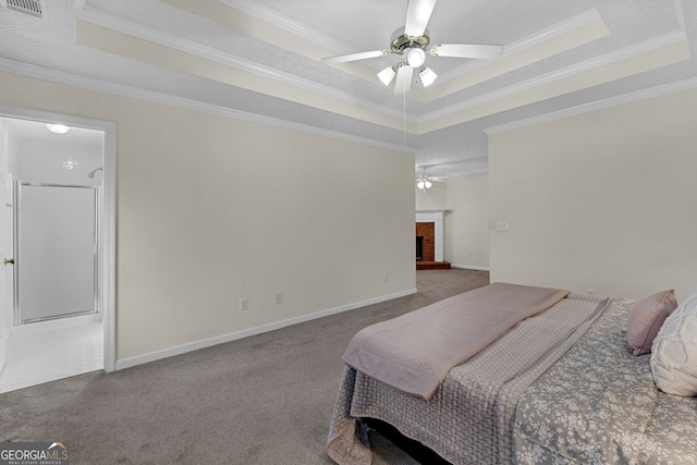 bedroom featuring a tray ceiling, a fireplace, carpet flooring, and baseboards