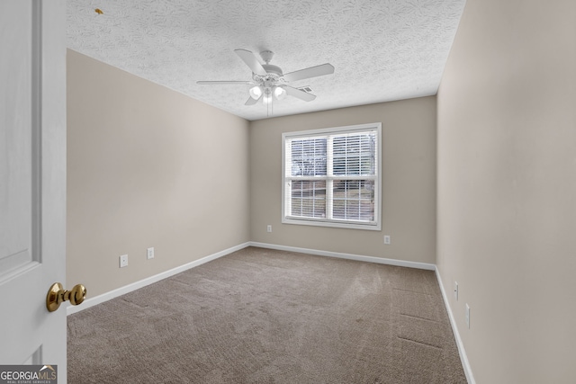 carpeted empty room featuring a textured ceiling, baseboards, and a ceiling fan